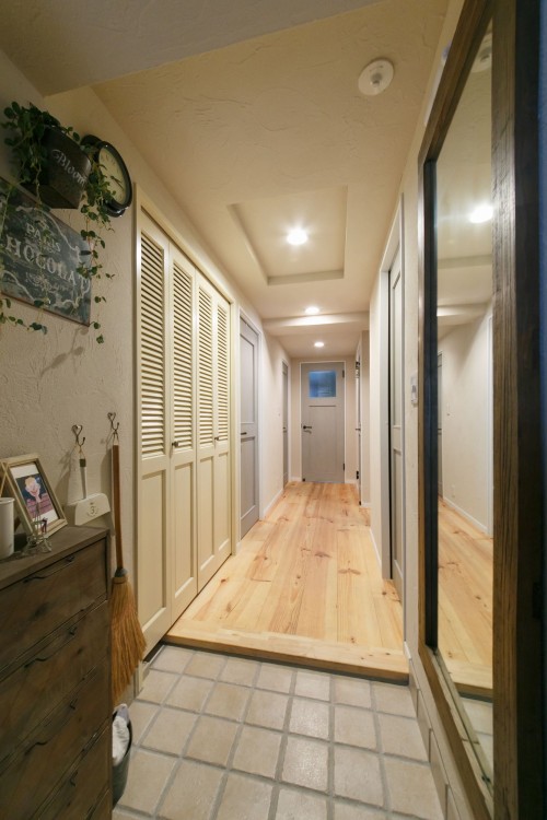 優しい雰囲気の素焼きタイルの玄関と無垢パイン材の廊下