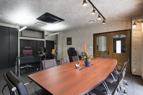 コンクリート柄のクロスにチェッカープレート柄の床で個性的な事務所スペース