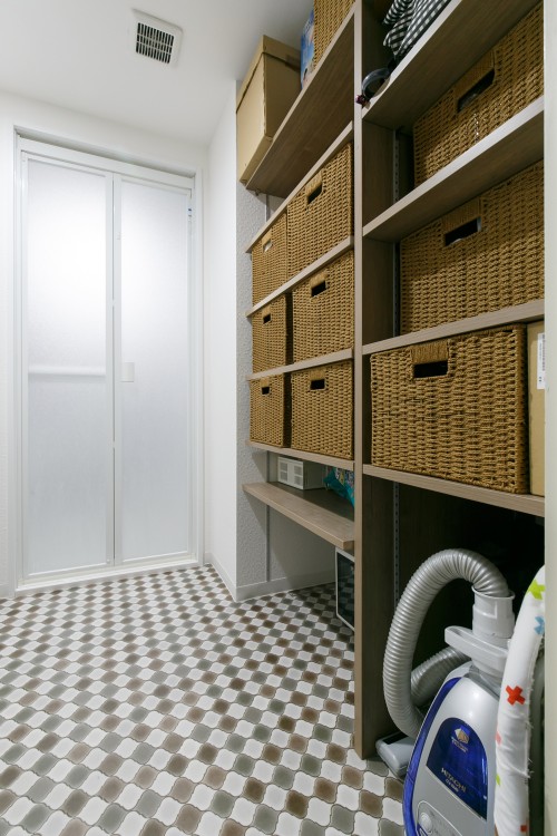 テラコッタ柄の床と大容量の収納棚のある洗面所
