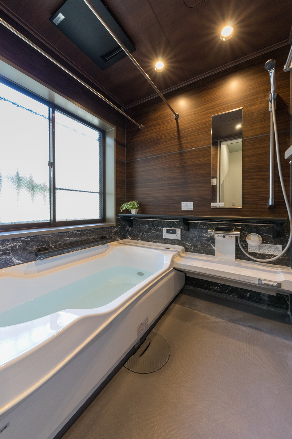ダイニングのカフェスタイル収納とリビングのストーン柄エコカラットプラスが上質な空間を演出する川崎市のリノベーション（浴室）