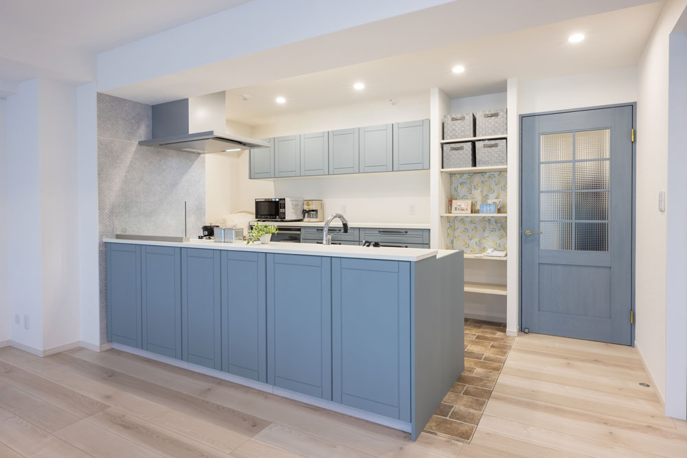 框風のブルーグレーの扉が特徴的なペニンシュラキッチン