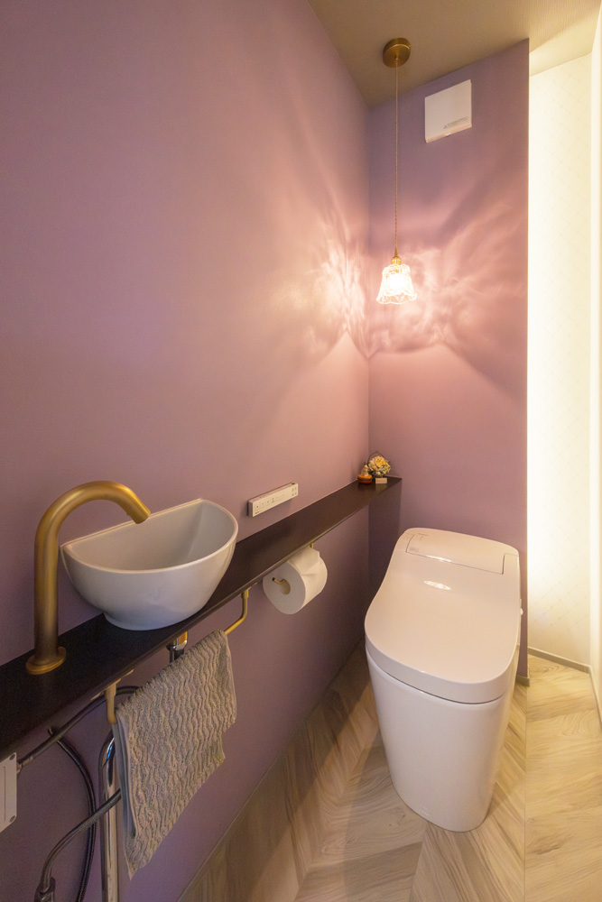 パープルのアクセントクロスを貼ったトイレ空間