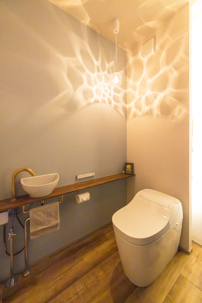 ブルーグレーのアクセントクロスをい貼ったトイレ空間