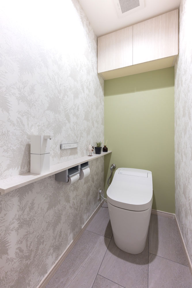 ボタニカル柄のクロスとモスグリーンのクロスをコーディネートしたトイレ空間